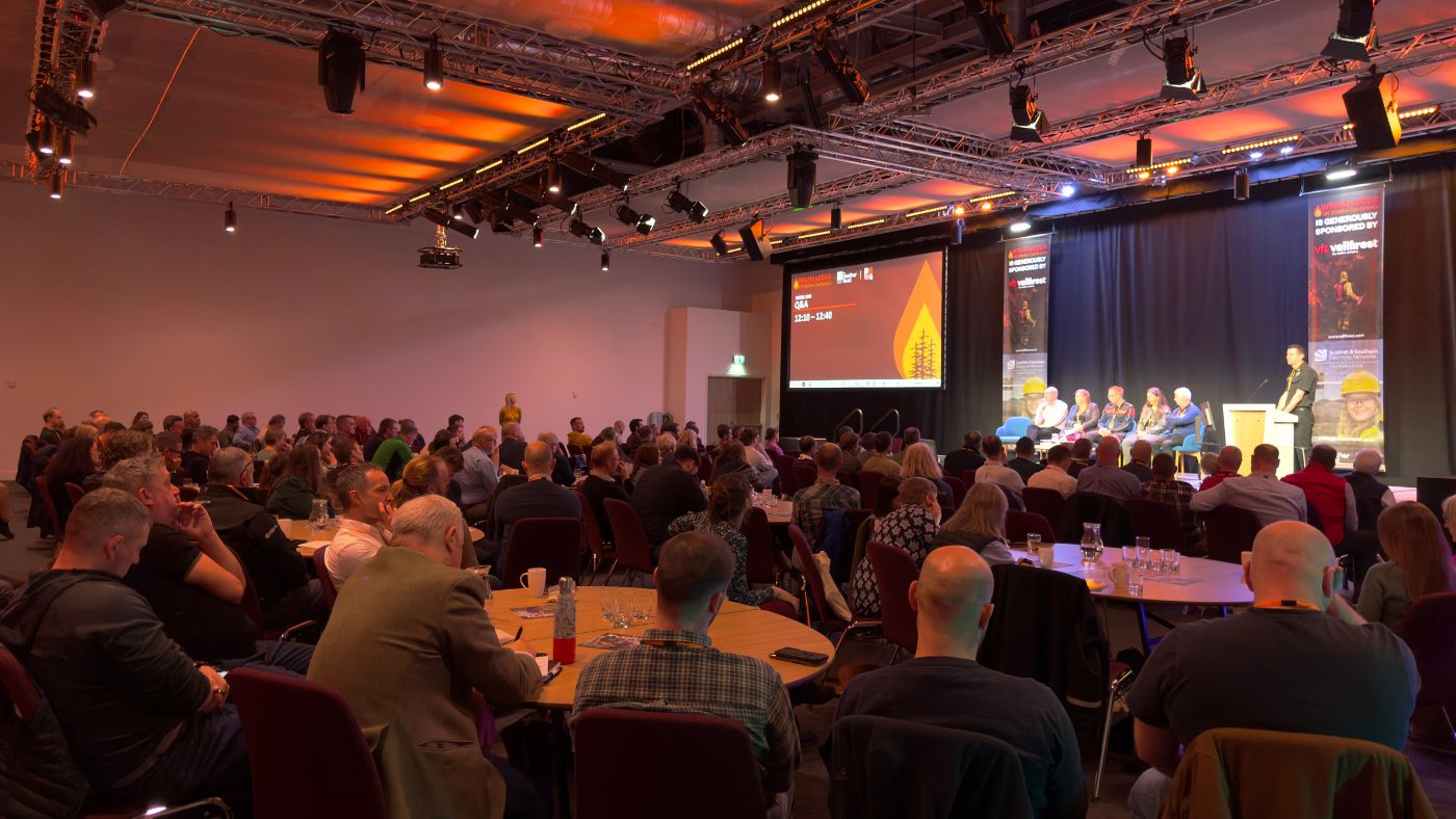 A packed conference room showcasing a large audience engaged in various discussions and activities around wildfires.