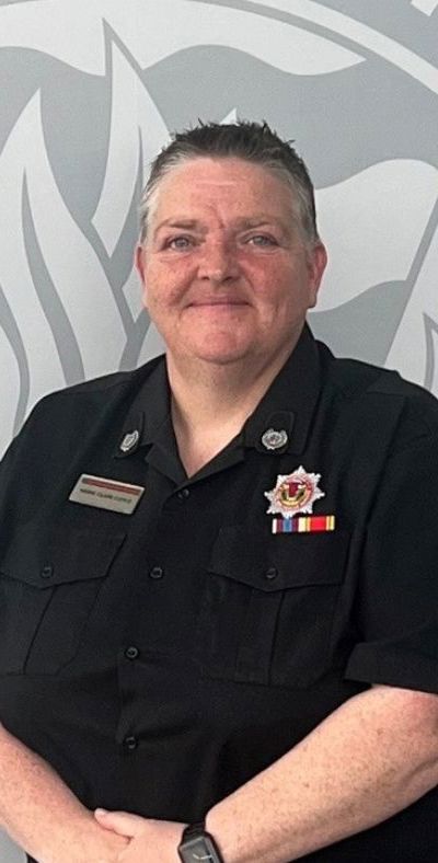 Group Commander Marie Clare Coyle in uniform in front of a crest SFRS crest