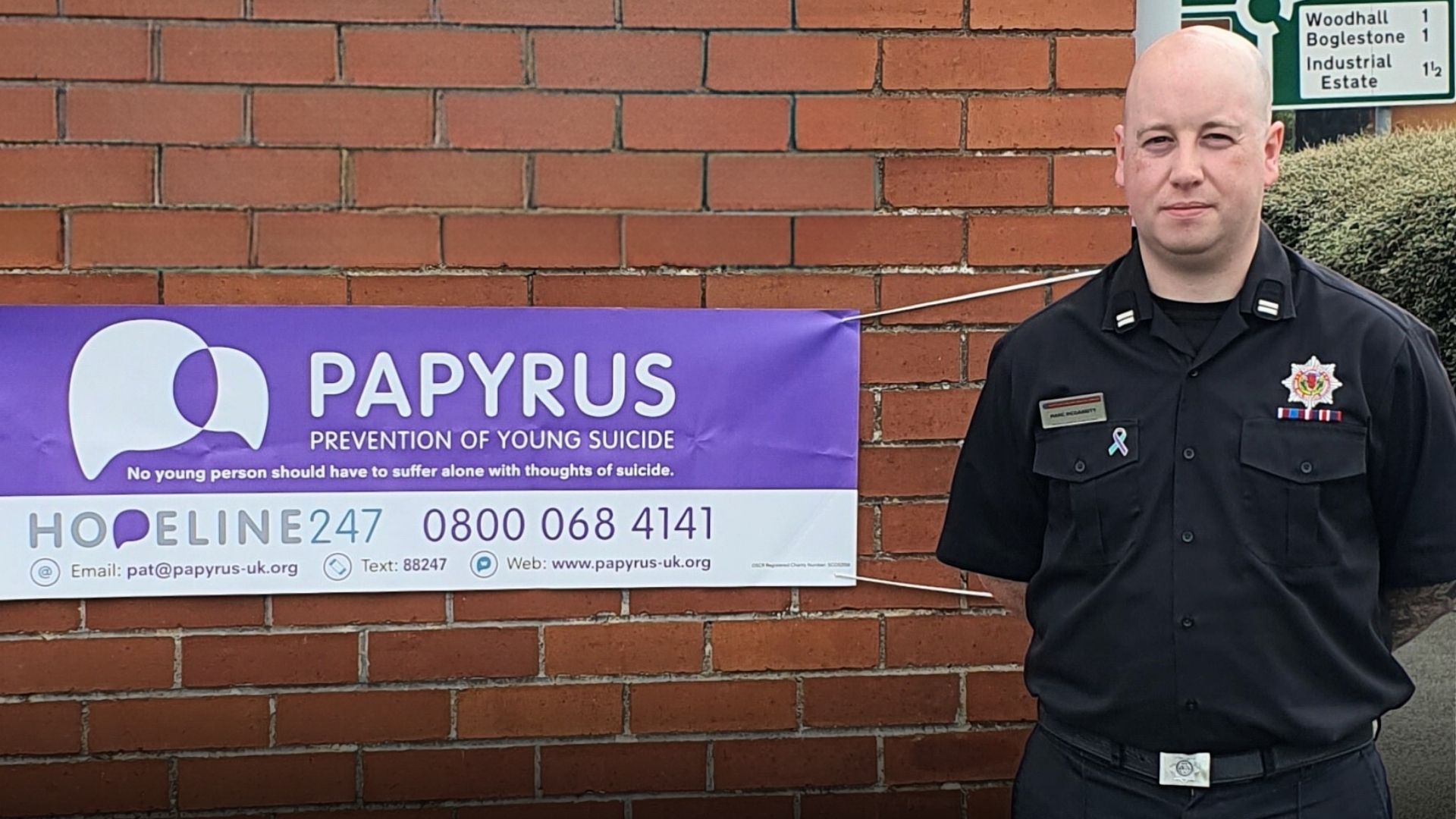 Man standing next to a sign for suicide prevention