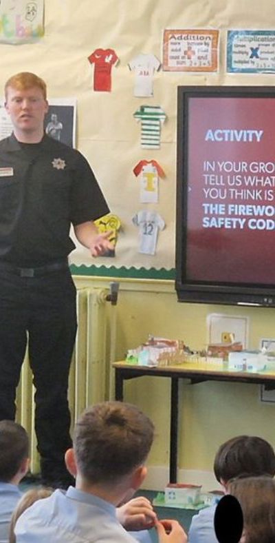 Firefighters giving a presentation to children in a classroom