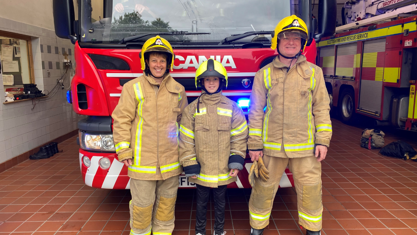 A picture of three people standing in front of a fire engine