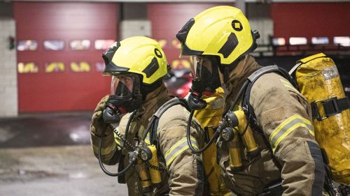 Two firefighters wearing breathing apparatus